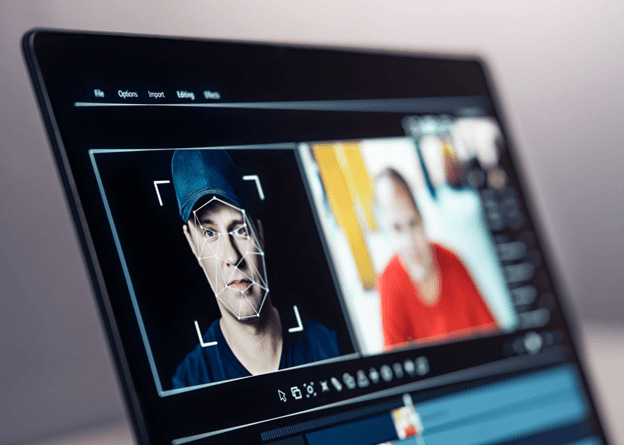 A laptop screen displays facial recognition software in action